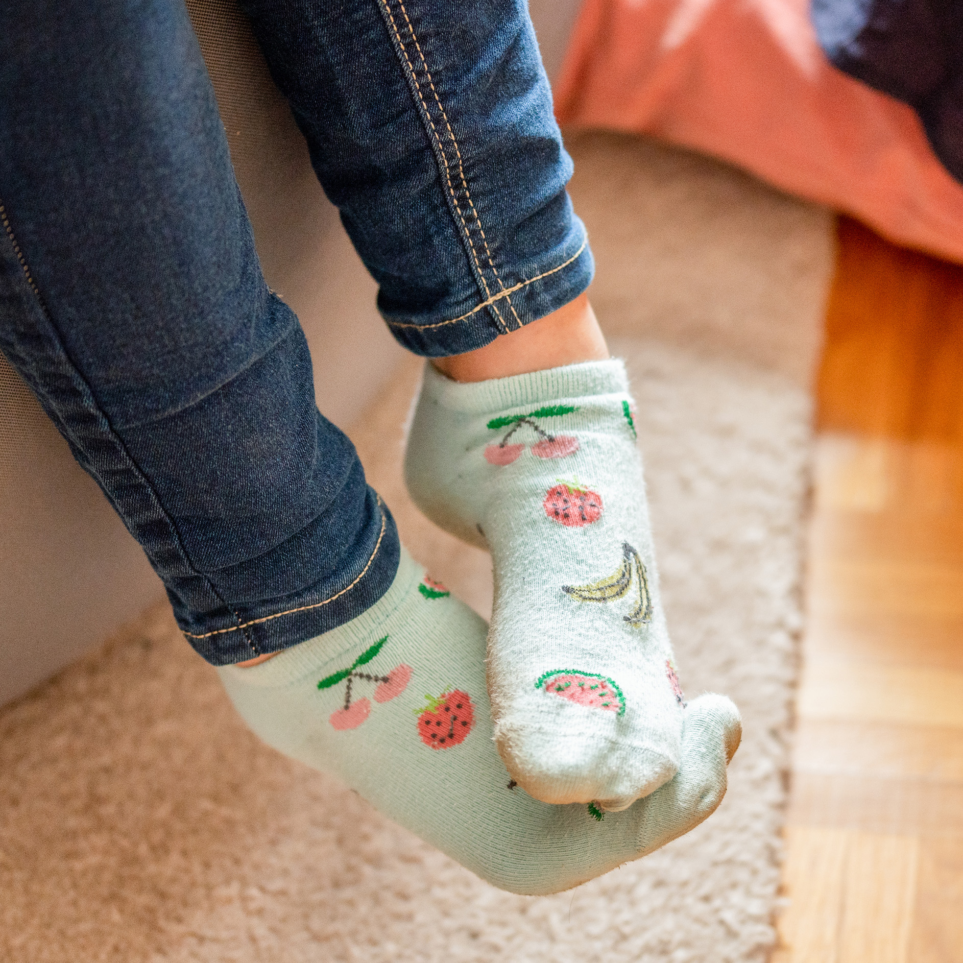Foto von Kinderfüßen mit bunten Socken.