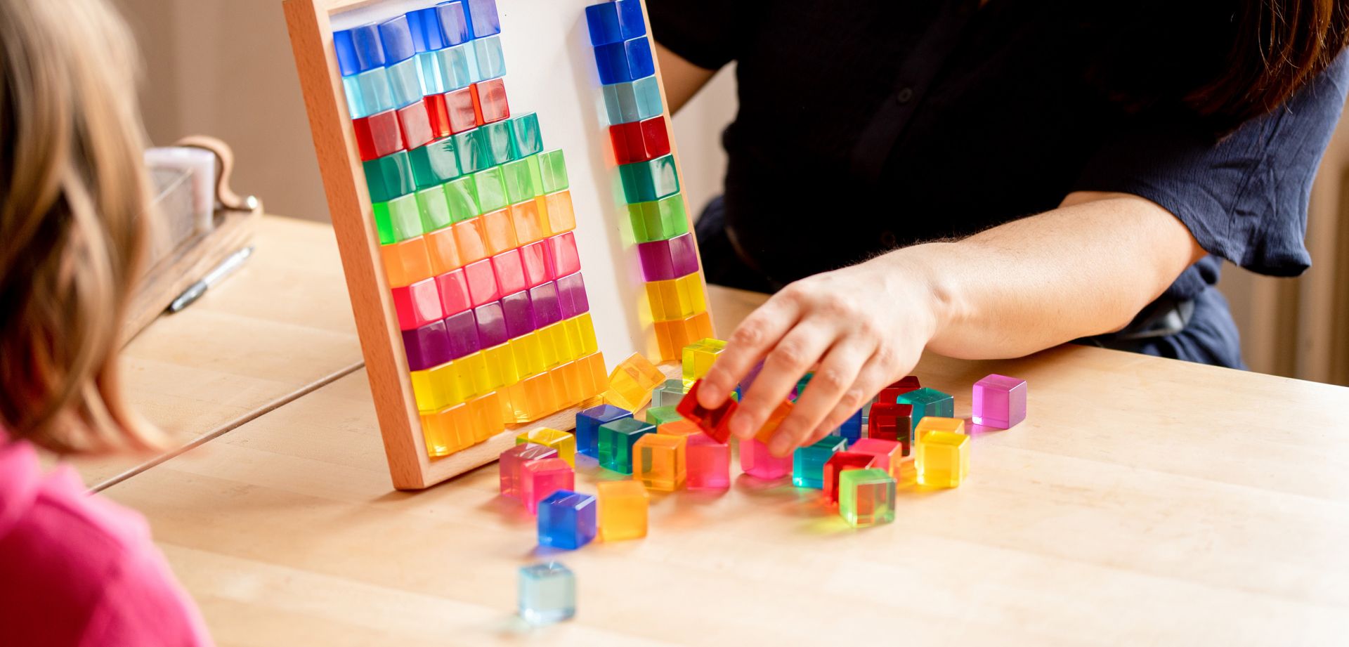 Bild von einer Hand, die Spielzeugsteine greift.